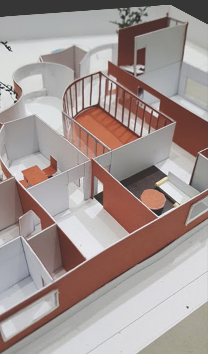 White and red card model of a house seen from above