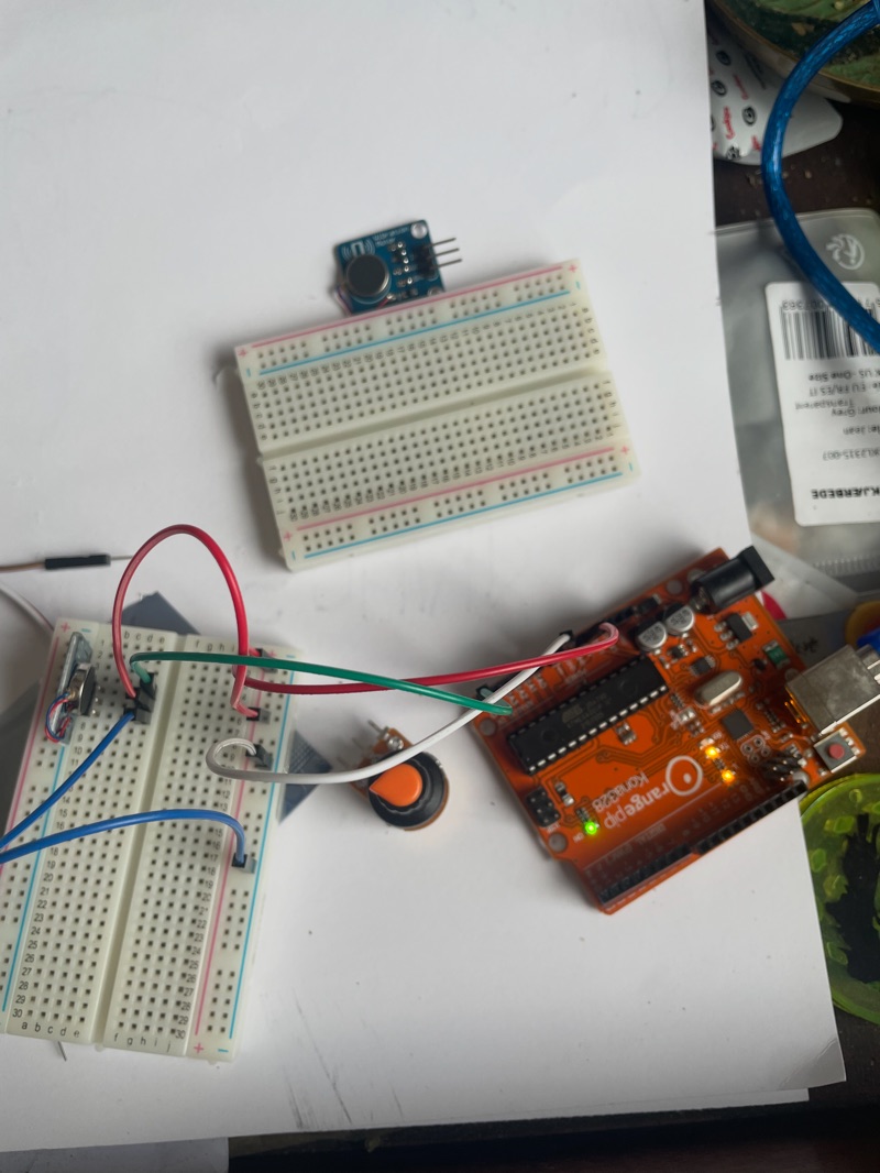 Arduino board wired to two breadboards with a push button and a small microphone module